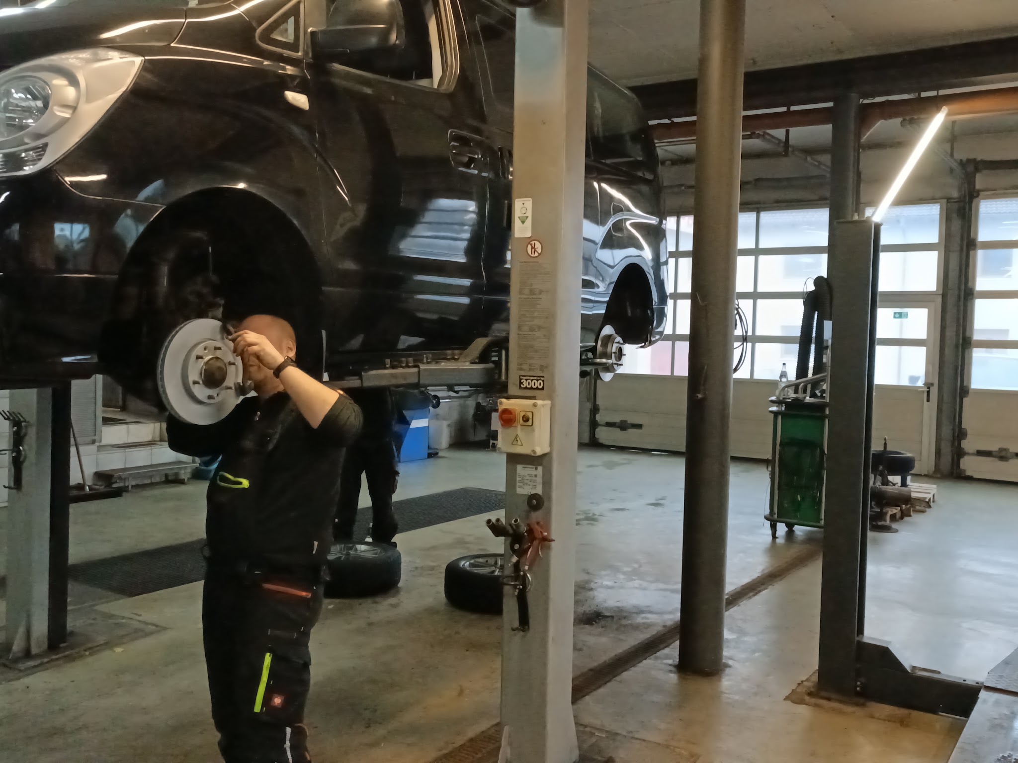 Werkstatt von REICHERT KFZ-Technik: Fahrzeug auf der Hebebühne während der Reparatur