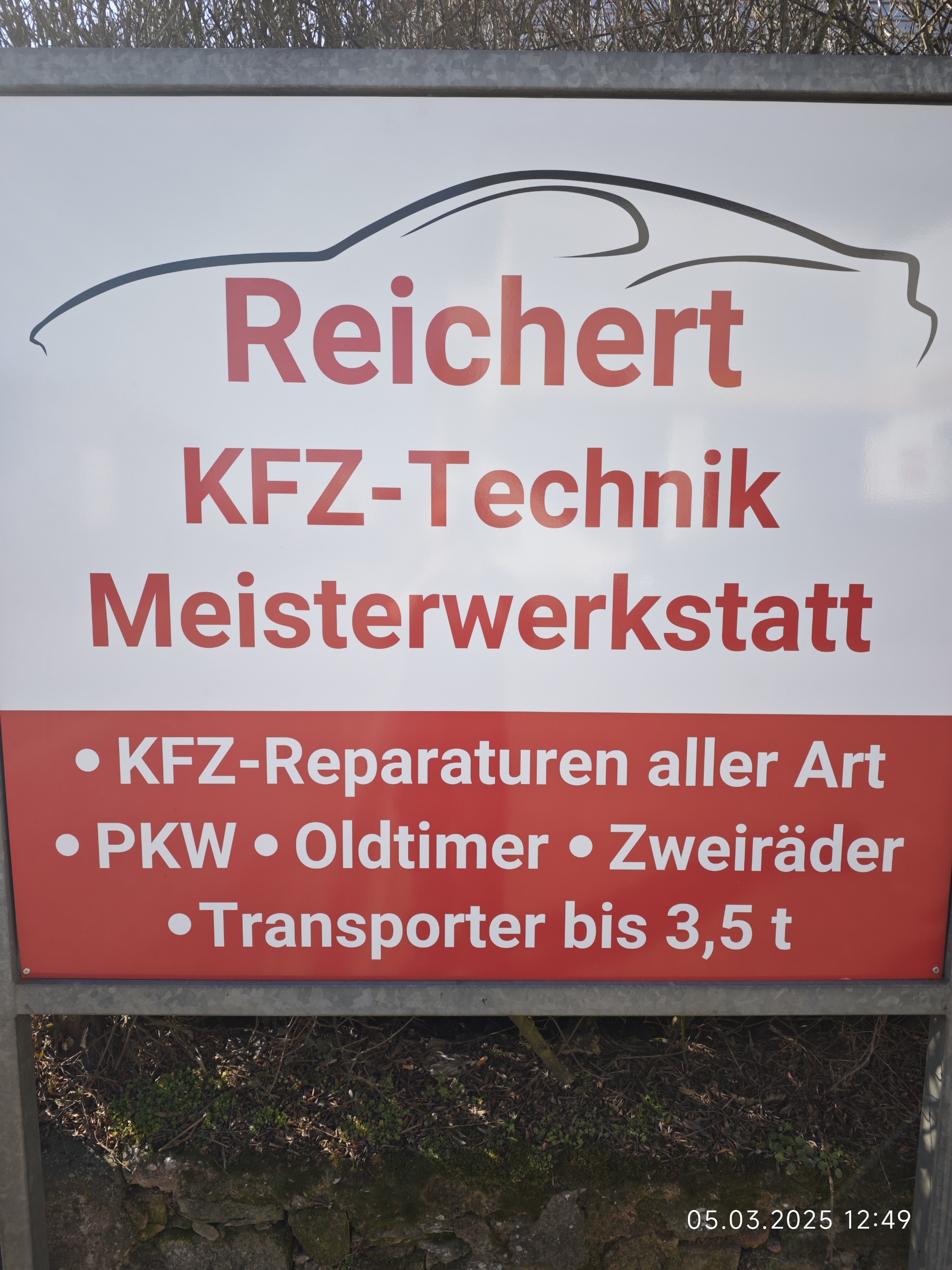 Firmenschild REICHERT KFZ-Technik Meisterwerkstatt vor der Werkstatt